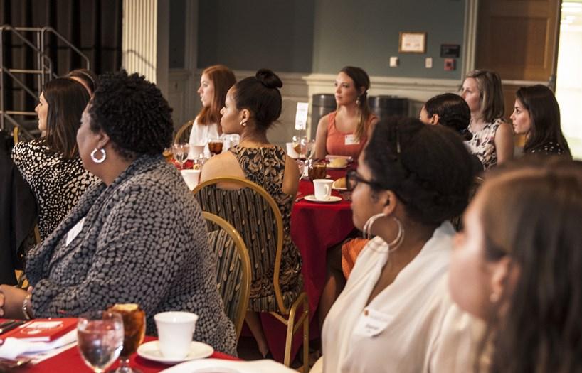 women sitting by table listening